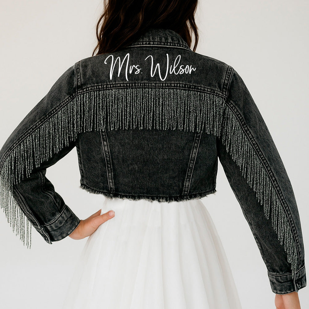 a woman wearing a jean jacket with fringes on it