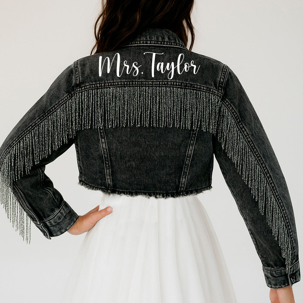 a woman wearing a black jean jacket with fringes