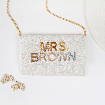 Chic Bridal Clutch: Personalized Seed Bead Clutch Purse for Brides, measuring 9 1/2″ wide x 5″ tall. Handcrafted with a velvet interior, this clutch offers both style and functionality for brides. Every handmade clutch is uniquely designed, making it an exquisite accessory for the special day.