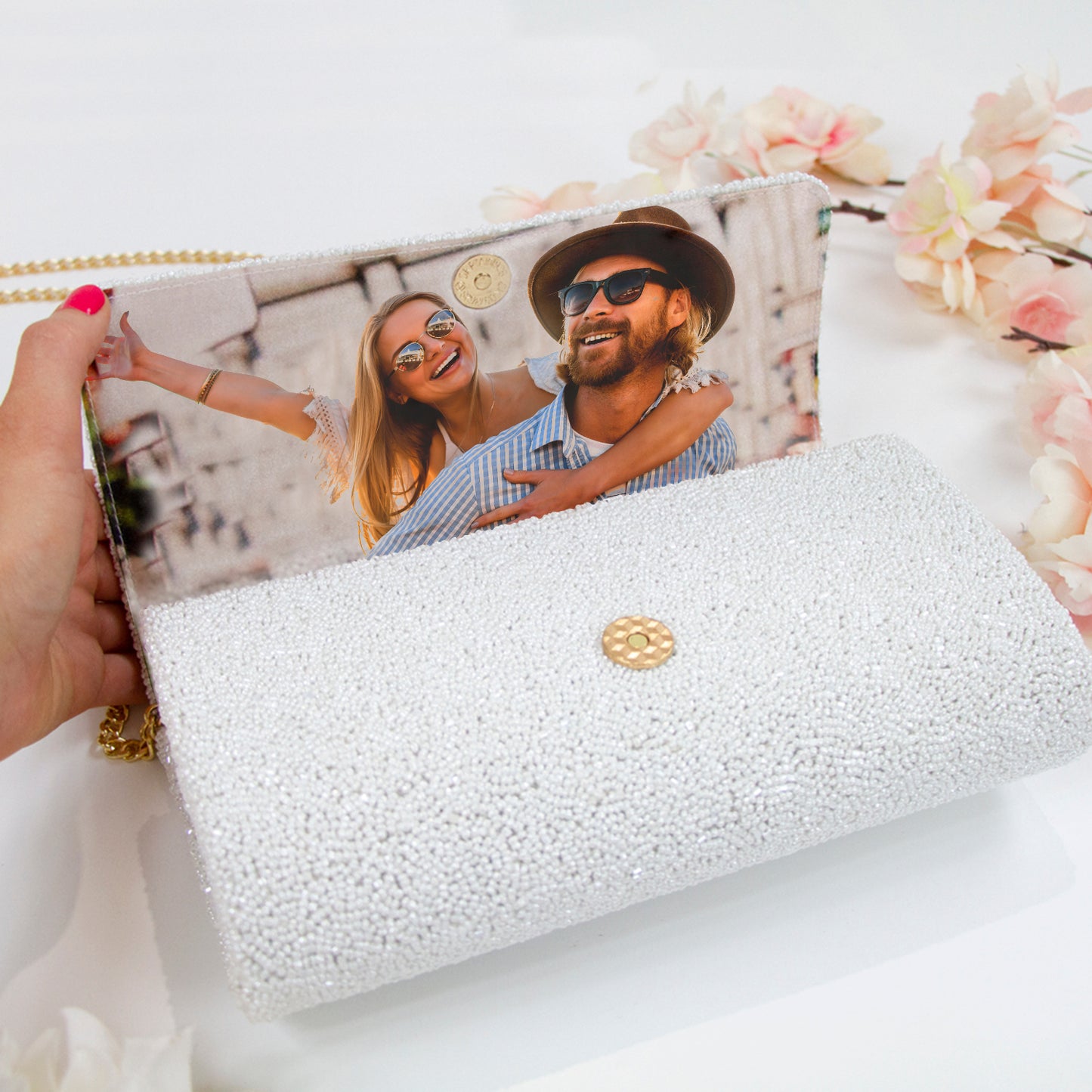 a woman holding a white purse with a picture of a man and woman on it