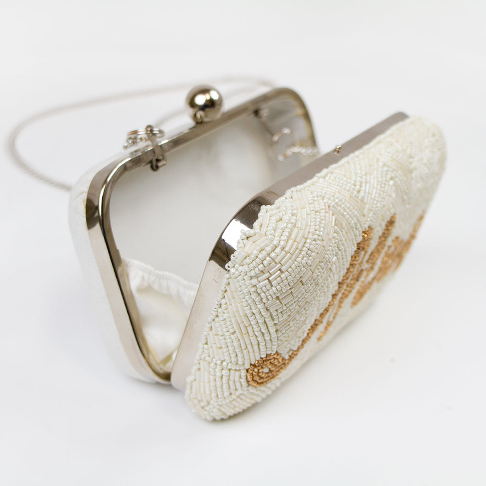 Elegantly handcrafted Bride, Mrs. Bridal Clutch in white with intricate gold text and beading. Perfect for a wedding day, this unique bridal clutch seamlessly blends functionality and style, holding all essentials with grace. A one-of-a-kind gift option for brides, showcasing the distinct beauty of artisanal craftsmanship.