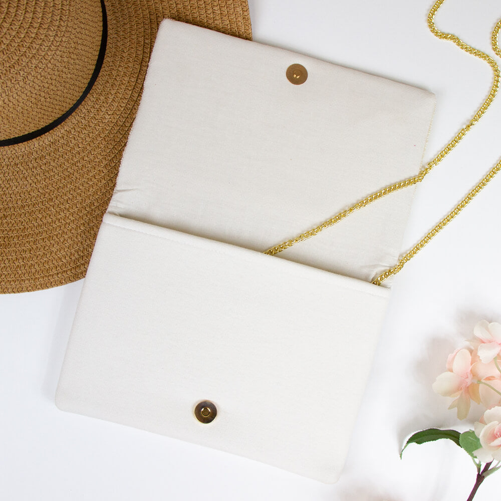 A beaded bridal clutch with 'Happily Ever After' text in gold, adorned with intricate floral patterns. Made from durable canvas, this 7 x 9.5 x 1 inch clutch showcases the unique charm of handmade items, ensuring no two are exactly alike. Ideal for holding wedding day essentials.