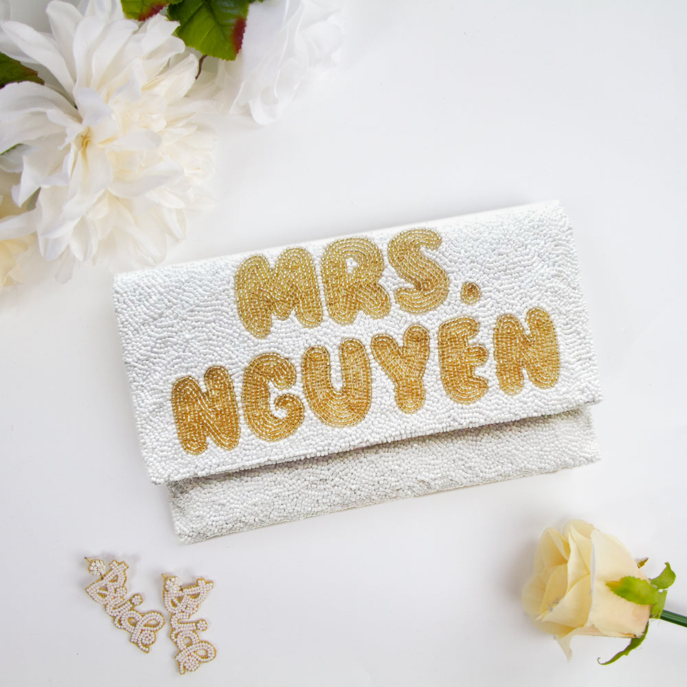 Handmade bridal clutch featuring bubble letters seed bead design, perfect for wedding day essentials. Elegant and unique addition for brides.