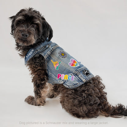 a dog wearing a jean jacket with patches on it