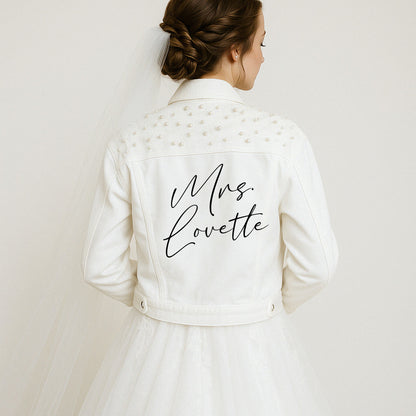 a woman in a wedding dress with a jacket on her back