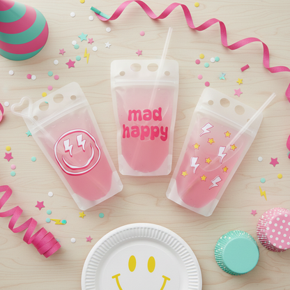 three pink drink bags with the words "mad happy" printed on them, surrounded by party decorations such as confetti, a party hat, and cupcakes.