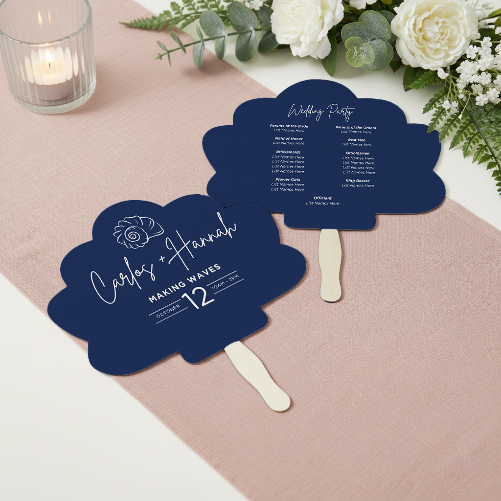 a blue fan-shaped wedding program with white text, placed on a pink tablecloth.