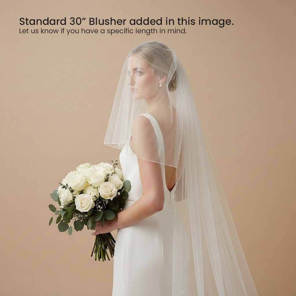 A woman in a white wedding dress holding a bouquet of white roses stands against a peach-colored background.