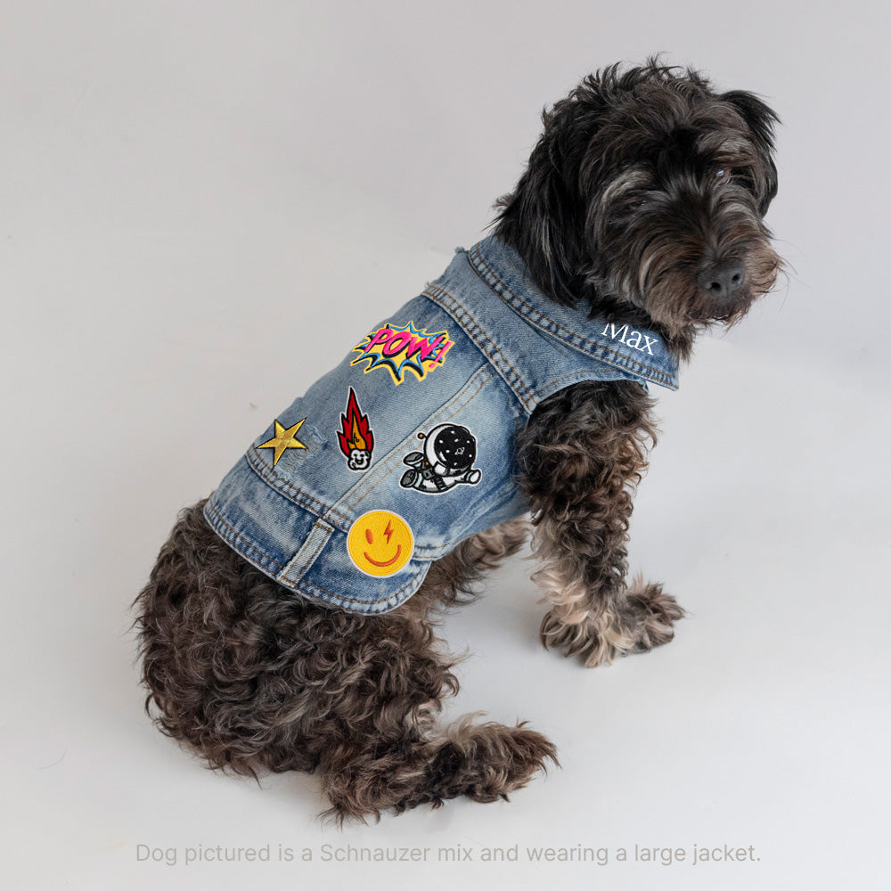 a dog wearing a jean jacket with patches on it