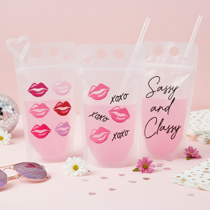 Three pink drink pouch holders with pink lips and the text "xoxo xoxo xoxo" printed on them, along with a pair of sunglasses and some pink flowers.
