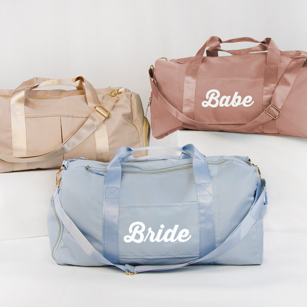 three duffel bags with bride and groom written on them