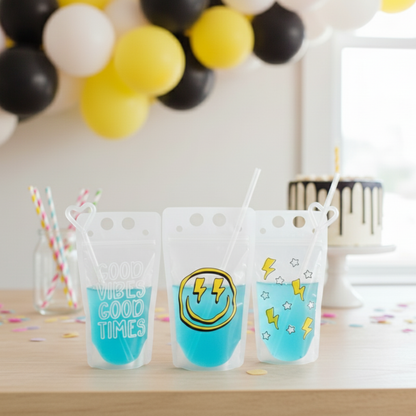 Three colorful drink cups with straws, each containing a different colored liquid, placed on a table with balloons in the background.