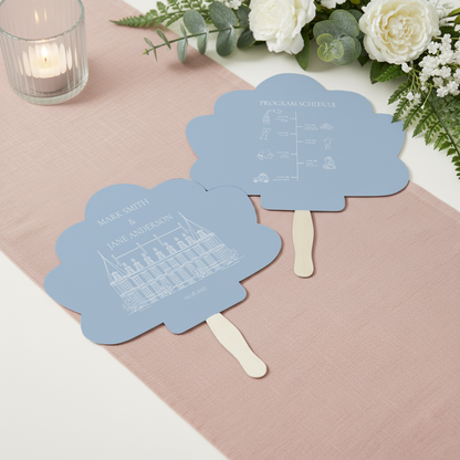 two blue fan-shaped cards with white text and illustrations, placed on a pink tablecloth.