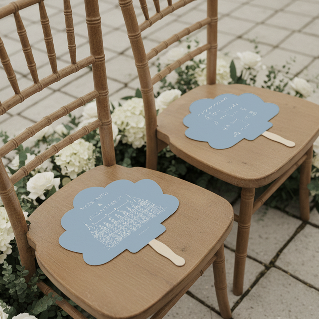 two wooden chairs with blue fans on them, placed on a tiled floor surrounded by white flowers.