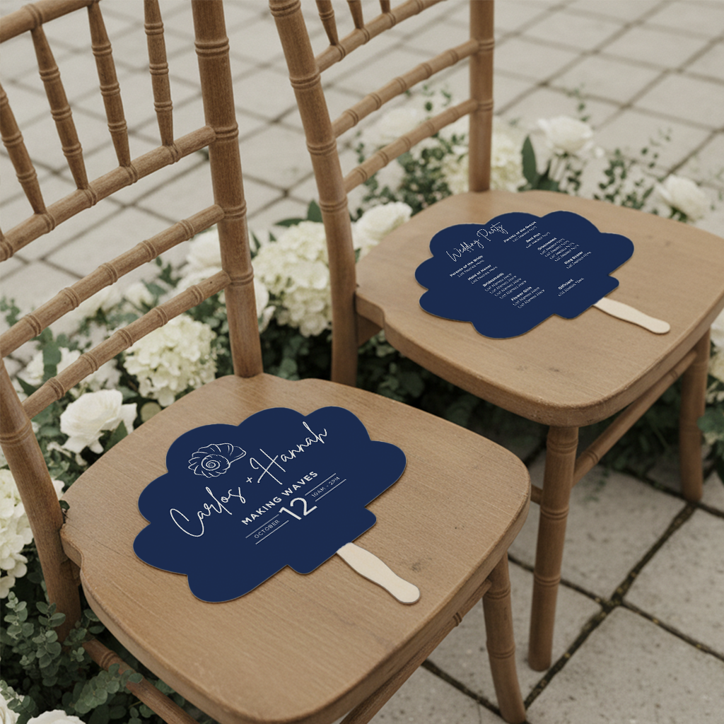 two wooden chairs with blue fans on them, placed on a tiled floor surrounded by white flowers.