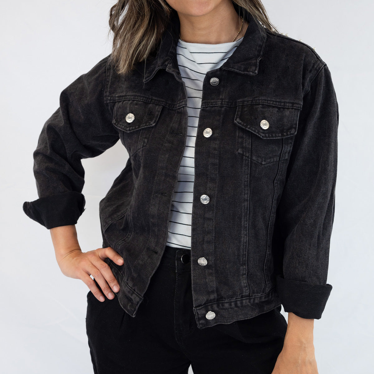 a woman wearing a black jean jacket and striped shirt