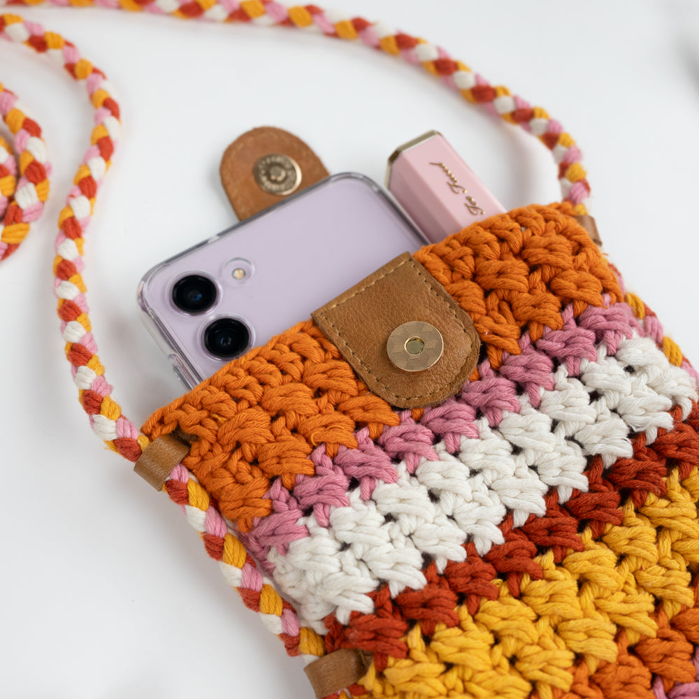 Boho-inspired Small Crossbody Cell Phone Purse, intricately crocheted in a stylish design. Measuring 5.25 in x 6.5 in x.5 in, it comfortably fits standard-sized phones and small essentials like a thin wallet or lip gloss. The 42 in strap allows it to drape effortlessly as a crossbody, secured with a sturdy leather magnetic snap closure. A chic and practical accessory, ideal for brides looking for a blend of function and fashion.