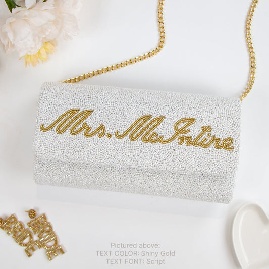 Handcrafted Custom Mrs (Last Name) Bridal Clutch, adorned with intricate beading and available with a gold or silver chain. Measuring 9.5in x 5in x 3in, this unique bridal clutch is perfect for holding wedding day essentials and offers an option for an interior custom date. Each clutch is a testament to the beauty and individuality of handmade items