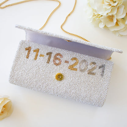 Elegant bridal clutch adorned with intricate beadwork, perfect accessory for a wedding ensemble.