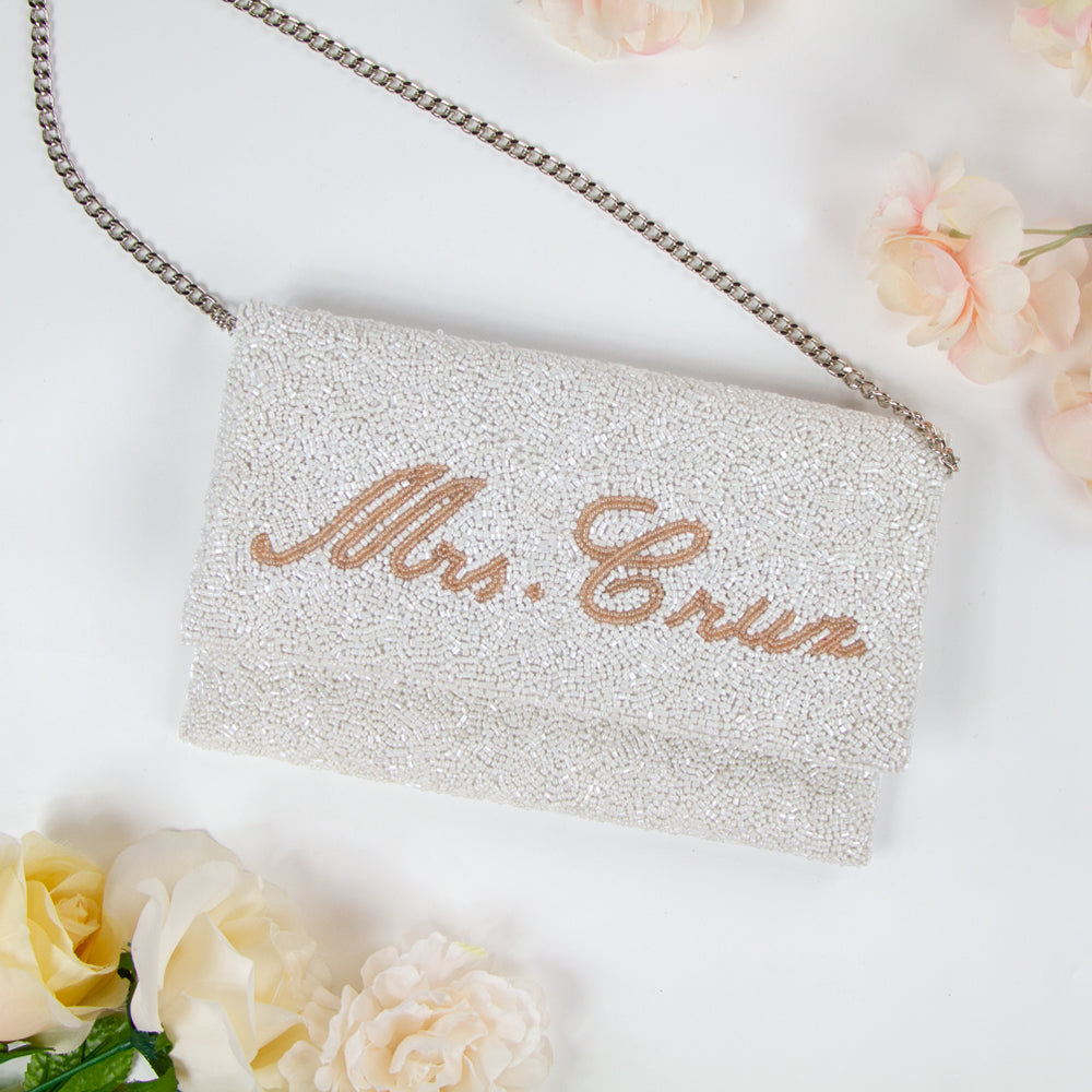 Chic Bridal Clutch: Personalized Seed Bead Clutch Purse for Brides, measuring 9 1/2″ wide x 5″ tall. Handcrafted with a velvet interior, this clutch offers both style and functionality for brides. Every handmade clutch is uniquely designed, making it an exquisite accessory for the special day.
