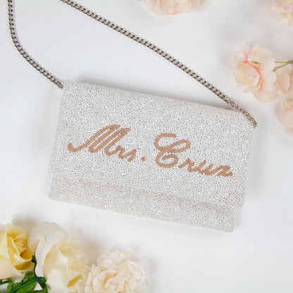 Chic Bridal Clutch: Personalized Seed Bead Clutch Purse for Brides, measuring 9 1/2″ wide x 5″ tall. Handcrafted with a velvet interior, this clutch offers both style and functionality for brides. Every handmade clutch is uniquely designed, making it an exquisite accessory for the special day.