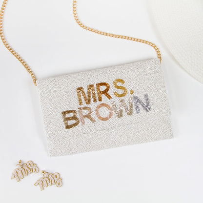 Handmade bridal clutch featuring bubble letters seed bead design, perfect for wedding day essentials. Elegant and unique addition for brides.