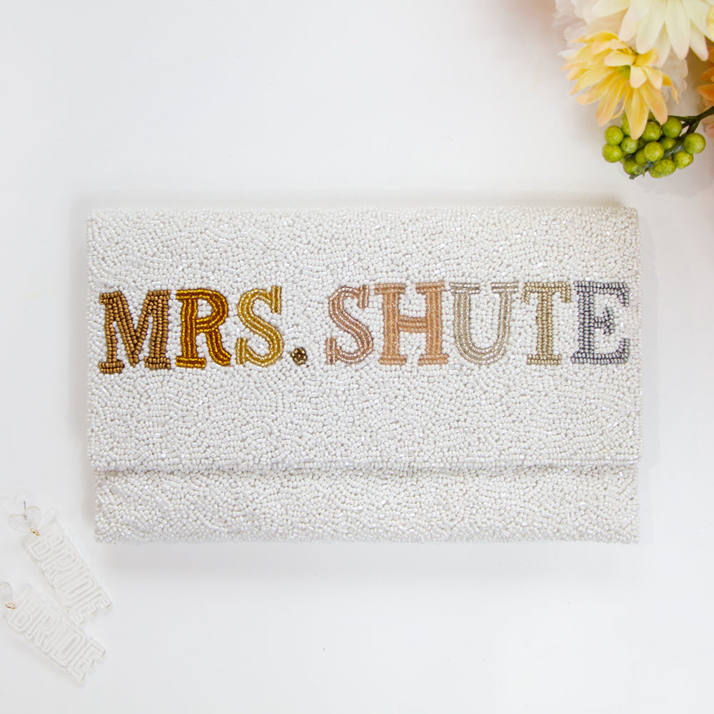 Chic Bridal Clutch: Personalized Seed Bead Clutch Purse for Brides, measuring 9 1/2″ wide x 5″ tall. Handcrafted with a velvet interior, this clutch offers both style and functionality for brides. Every handmade clutch is uniquely designed, making it an exquisite accessory for the special day.