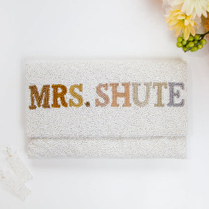 Chic Bridal Clutch: Personalized Seed Bead Clutch Purse for Brides, measuring 9 1/2″ wide x 5″ tall. Handcrafted with a velvet interior, this clutch offers both style and functionality for brides. Every handmade clutch is uniquely designed, making it an exquisite accessory for the special day.