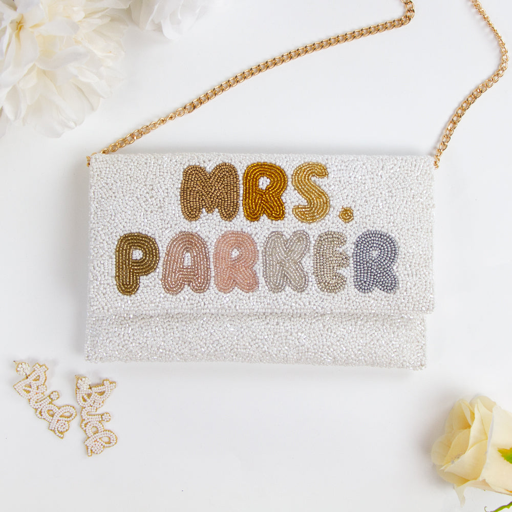 Handmade bridal clutch featuring bubble letters seed bead design, perfect for wedding day essentials. Elegant and unique addition for brides.