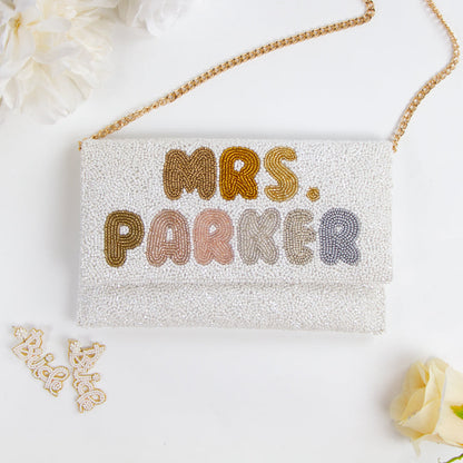 Handmade bridal clutch featuring bubble letters seed bead design, perfect for wedding day essentials. Elegant and unique addition for brides.