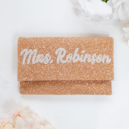 Chic Bridal Clutch: Personalized Seed Bead Clutch Purse for Brides, measuring 9 1/2″ wide x 5″ tall. Handcrafted with a velvet interior, this clutch offers both style and functionality for brides. Every handmade clutch is uniquely designed, making it an exquisite accessory for the special day.
