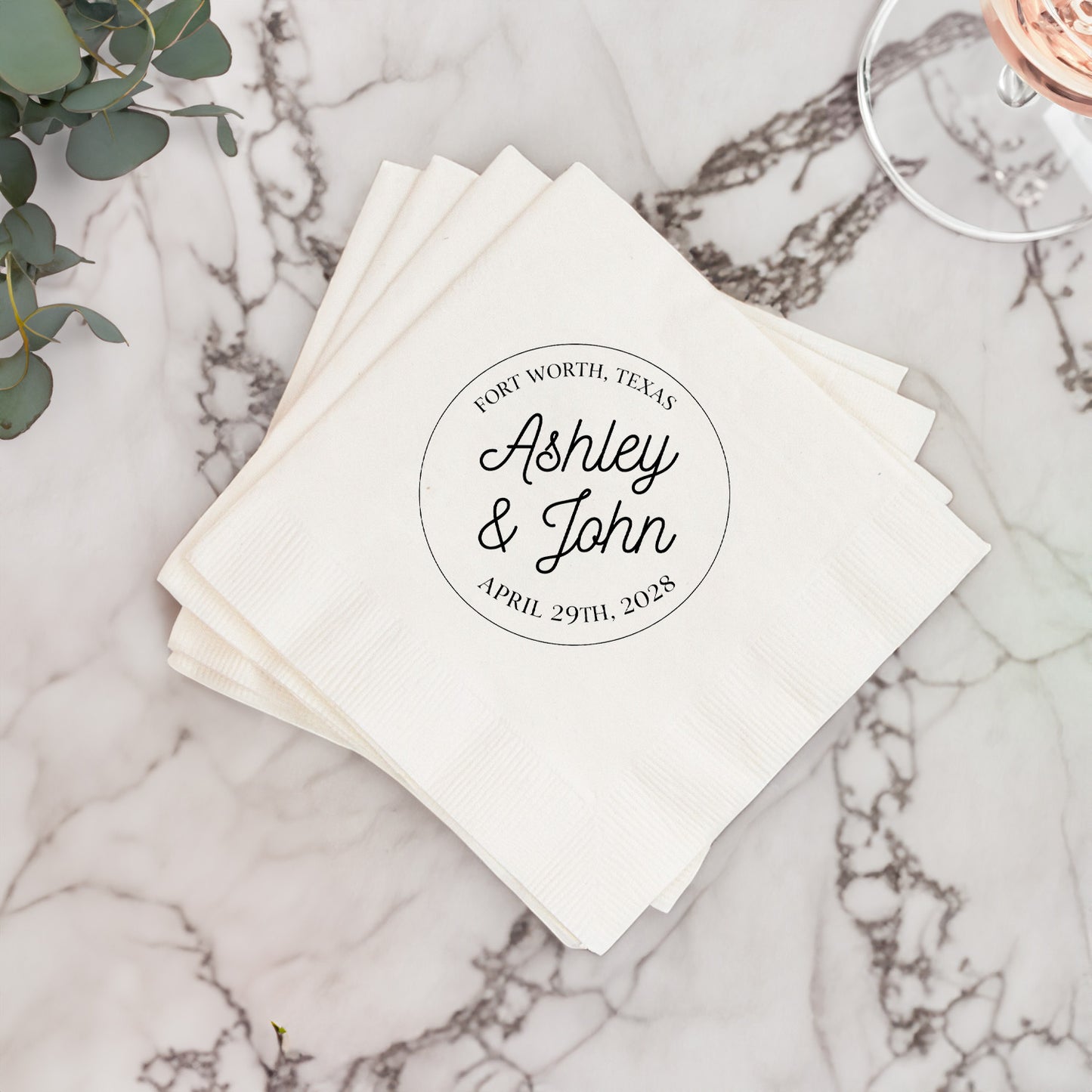 Stack of white napkins with personalized text on a marble surface
