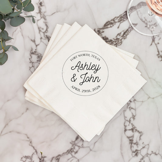 Stack of white napkins with personalized text on a marble surface