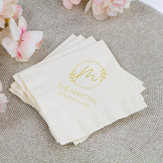 Stack of personalized napkins with a floral design and text on a textured surface with flowers.