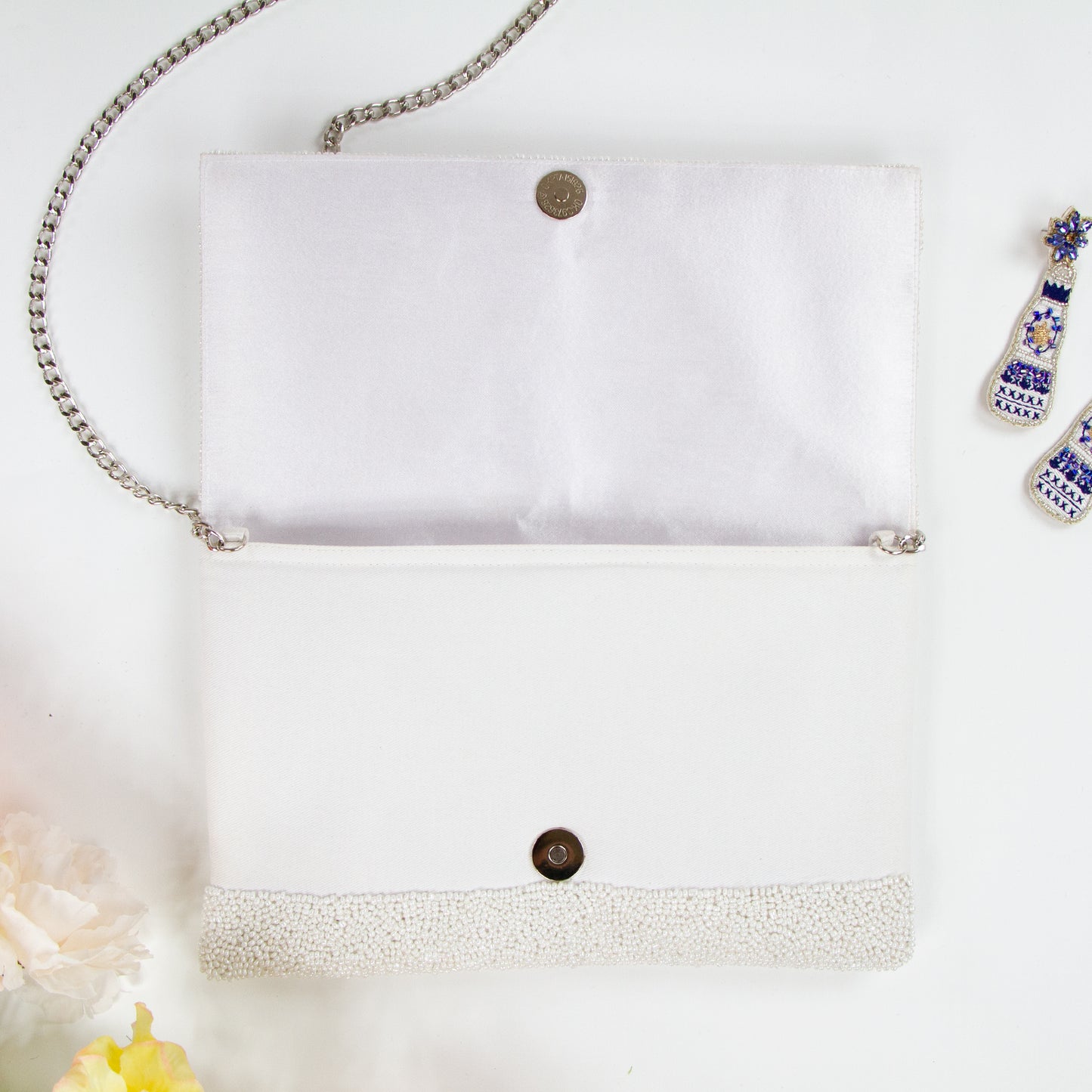 Title/bridal Clutch "Elegant white beaded bridal clutch, handmade to perfection, sized at 10.5 x 7 x 1 inches. This durable canvas bridal clutch with magnetic snap closure offers a stylish and practical solution for the wedding day, ensuring each bride has a unique accessory for her special occasion."