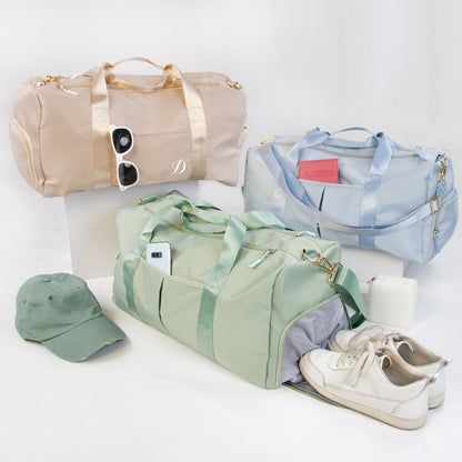 a collection of travel accessories, including three duffel bags in various colors, a hat, and a pair of sneakers.