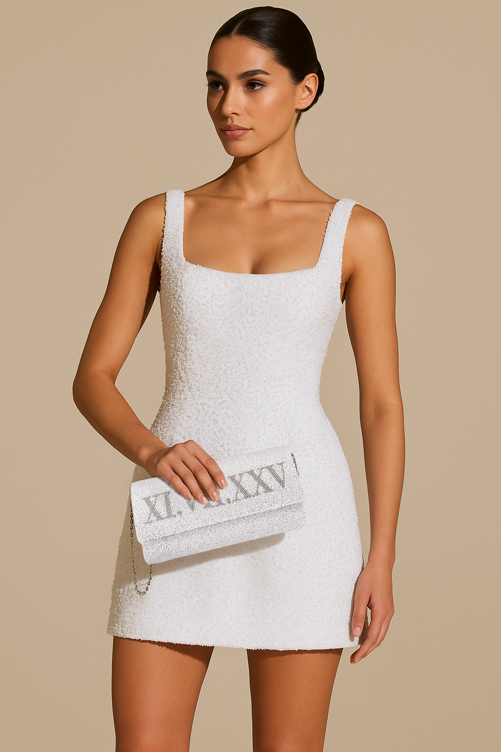A woman wearing a white dress and holding a white clutch purse with the number "XXV" printed on it.
