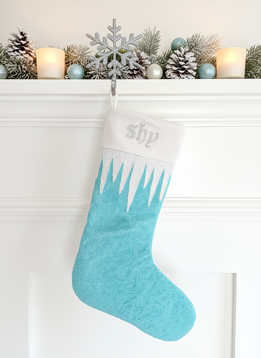 A turquoise Christmas stocking with a snowflake ornament and candles on a mantle.