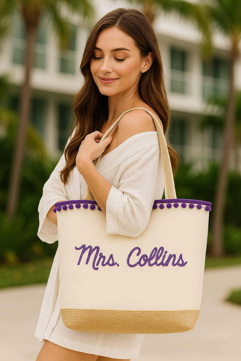 A young woman with long brown hair is smiling and holding a large tote bag with purple text that says "Mrs. Collins".