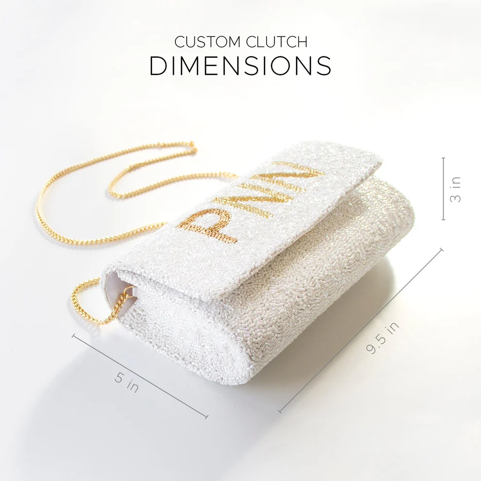 a white clutch purse with gold lettering on it.