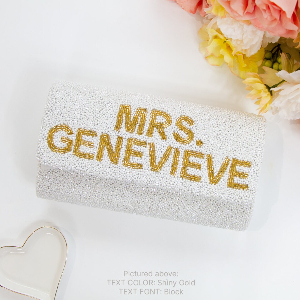 "Custom Mrs (Last Name)" beaded bridal clutch, intricately handmade for an elegant touch on the wedding day. Sized at 9.5in x 5in x 3in with an option for a gold or silver chain. Each bridal clutch boasts a unique character, highlighting the beauty of handcrafted items. Can be personalized with a custom date inside. An exquisite addition to any bridal ensemble or a thoughtful gift for soon-to-be brides.