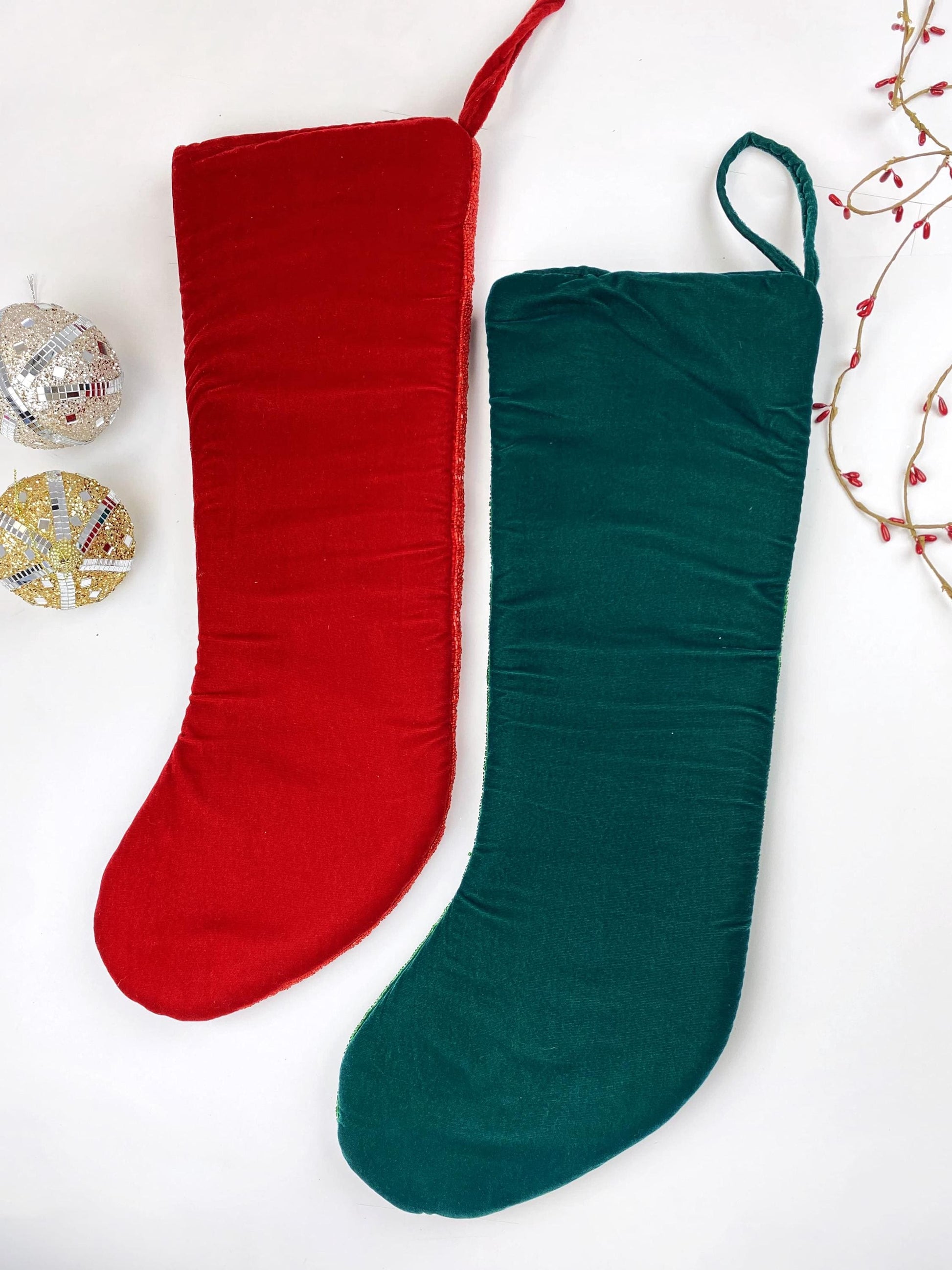 a pair of christmas stockings sitting next to a christmas ornament