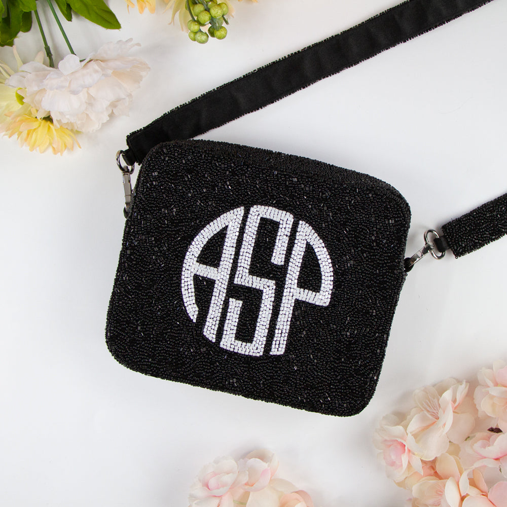 Customizable Monogram Crossbody Bag with beaded strap, ideal for summer and evening events. Features an 8x8 inch dimension, zipper closure, and a 46-inch detachable beaded strap. Each handcrafted piece boasts its unique color, texture, and bead pattern.