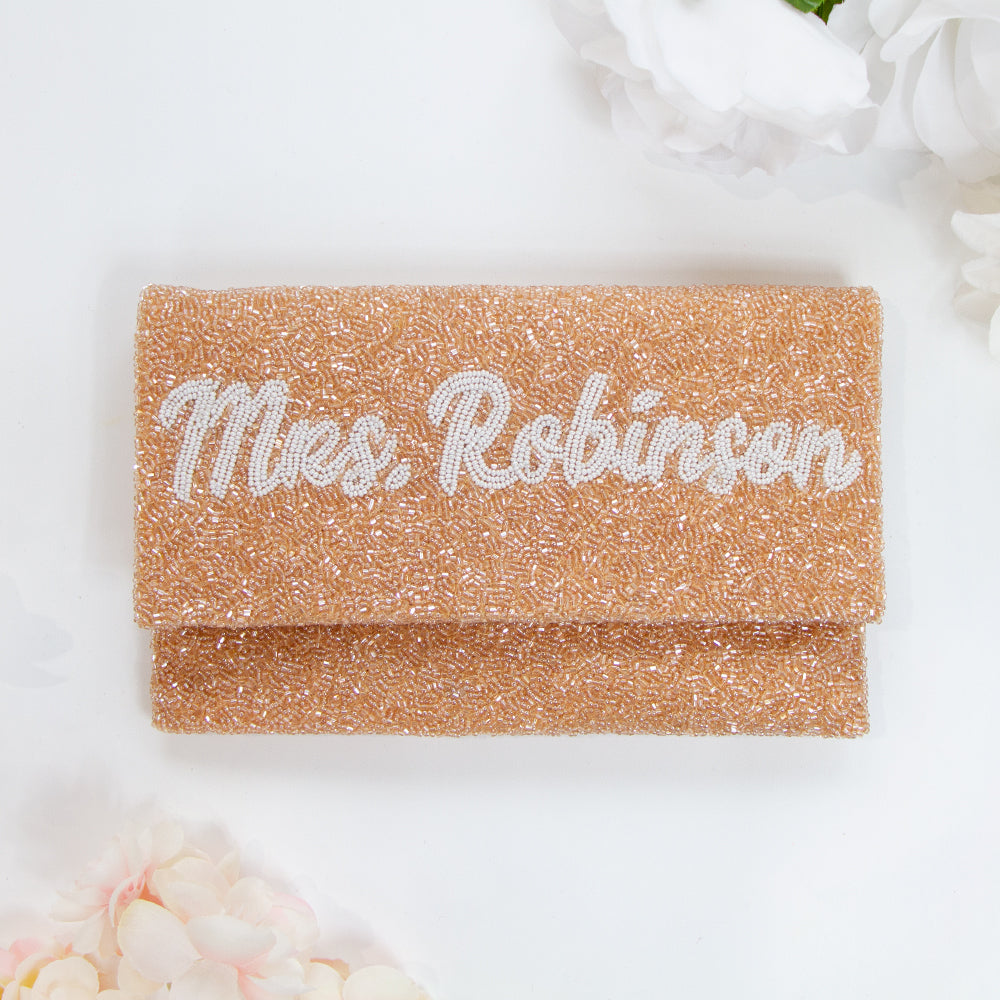 Exquisite Bridal Clutch: Custom Monogram Clutch Purse measuring 9 1/2″ wide x 5″ tall. Featuring rainbow clutch design with white text beading, complemented by a velvet interior. Each handmade clutch is unique, ideal for brides desiring a personalized touch on their special day