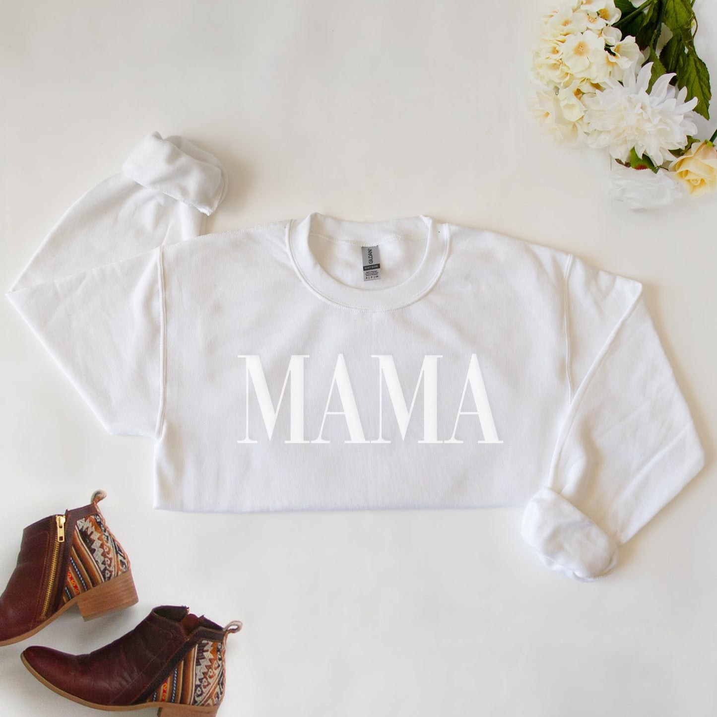 a white shirt that says mama next to a pair of brown boots