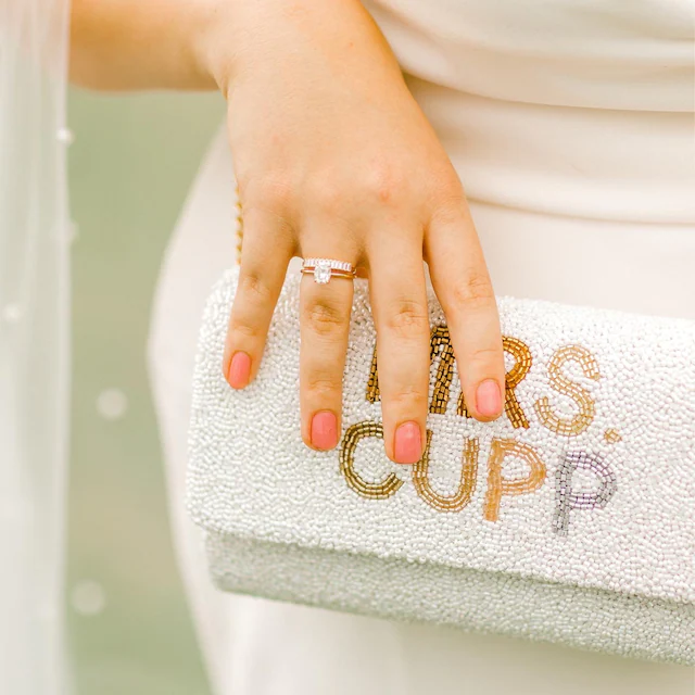 Elegant bridal clutch adorned with intricate beadwork, perfect accessory for a wedding ensemble. Color White